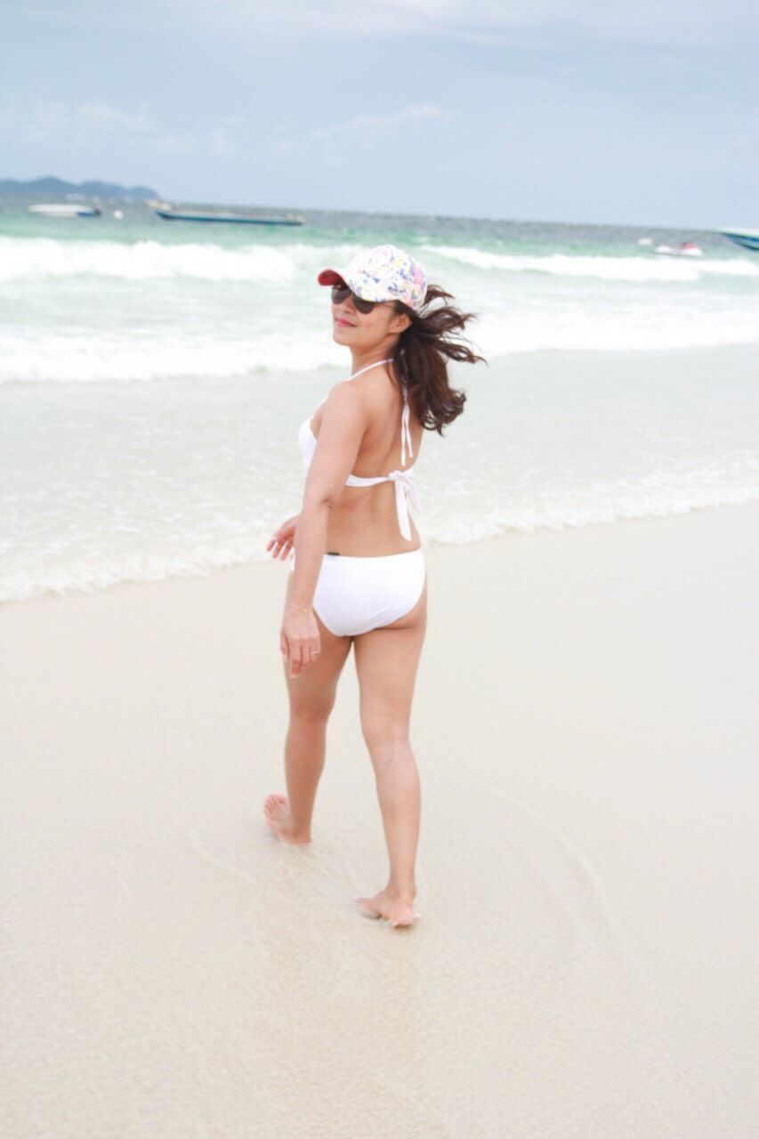 Woman wearing bikini while walking on sand at beach