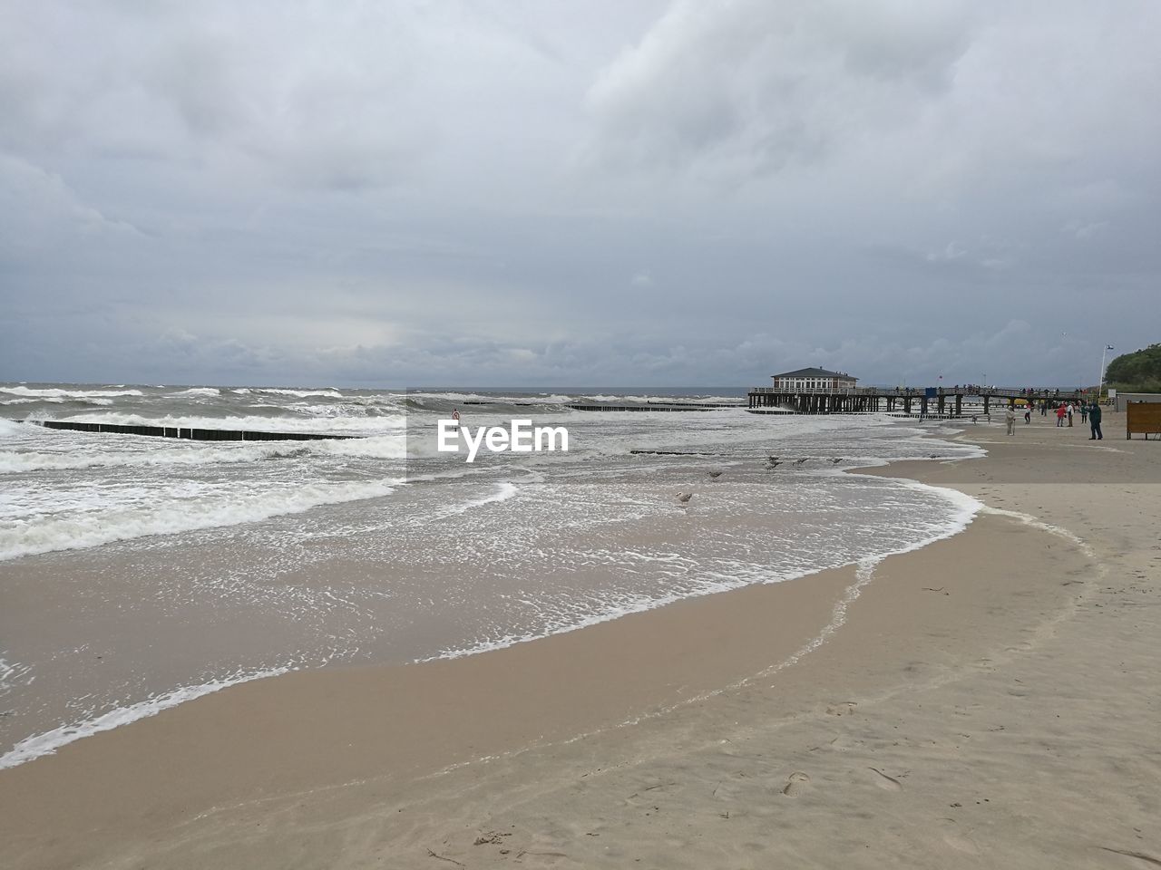 Scenic view of beach against cloudy sky