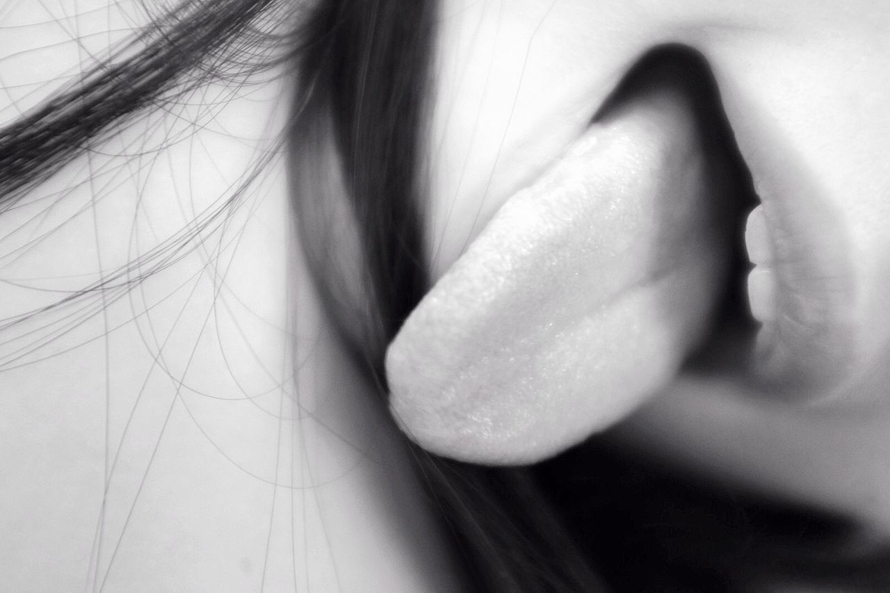 Extreme close up of woman sticking out tongue