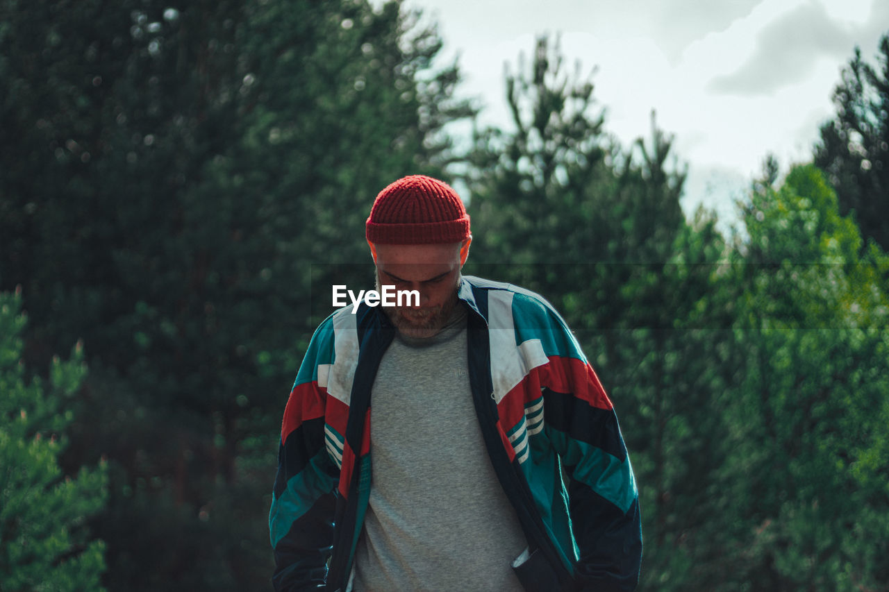 MAN STANDING IN FOREST