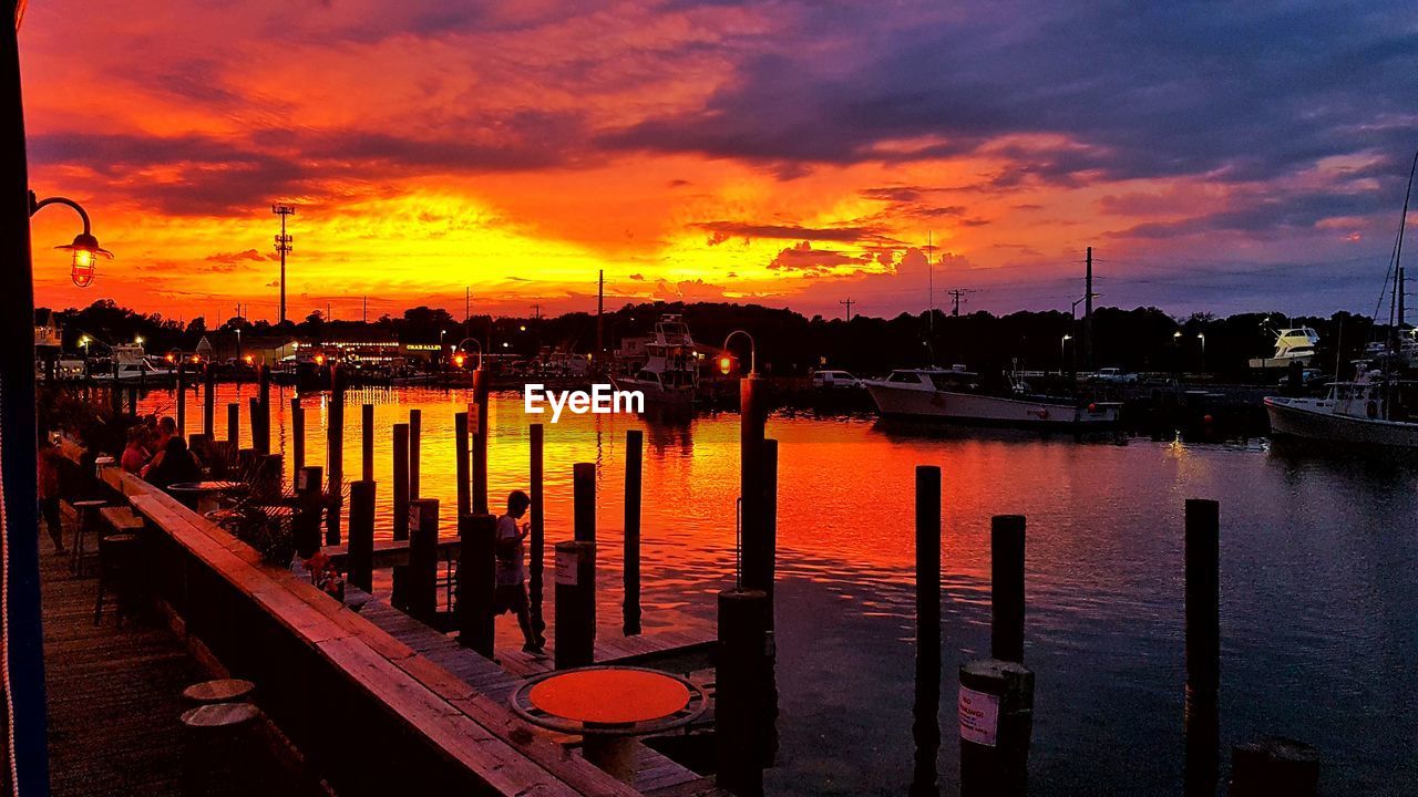 VIEW OF RIVER AGAINST CLOUDY SKY AT SUNSET