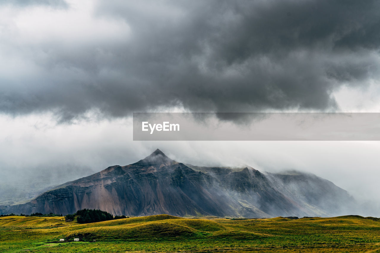 Scenic view of mountains against cloudy sky