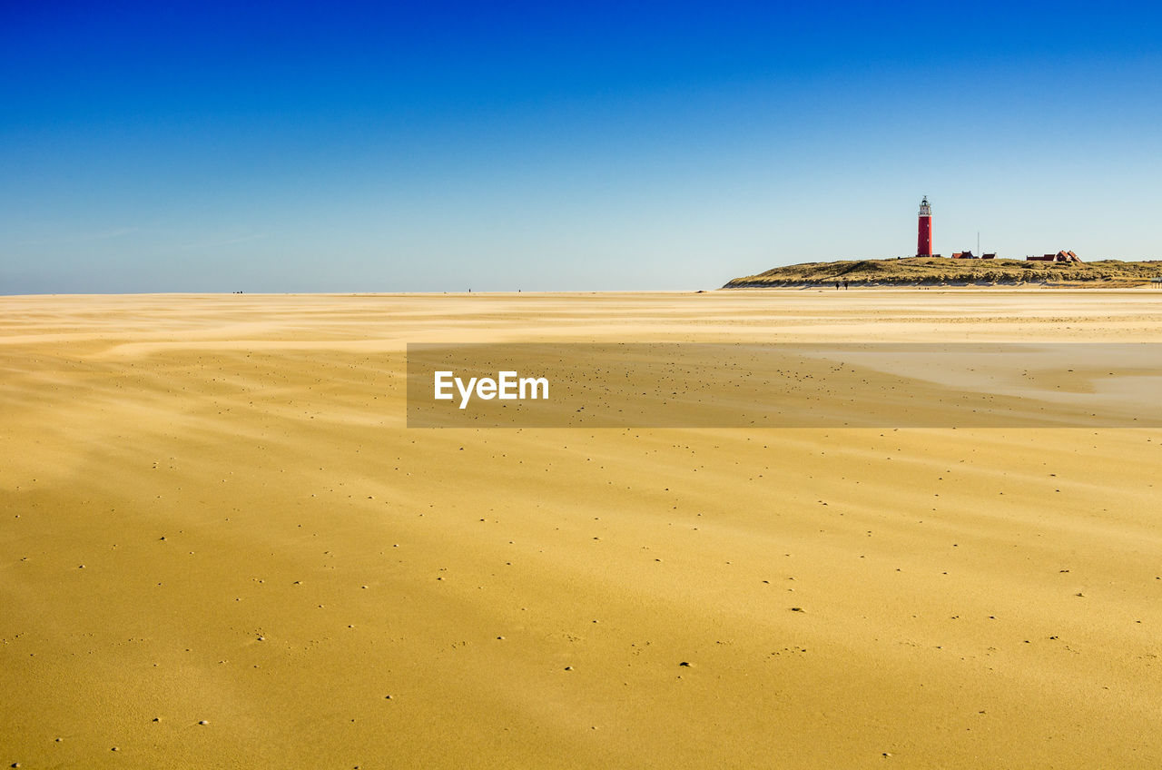 Scenic view of beach against clear blue sky