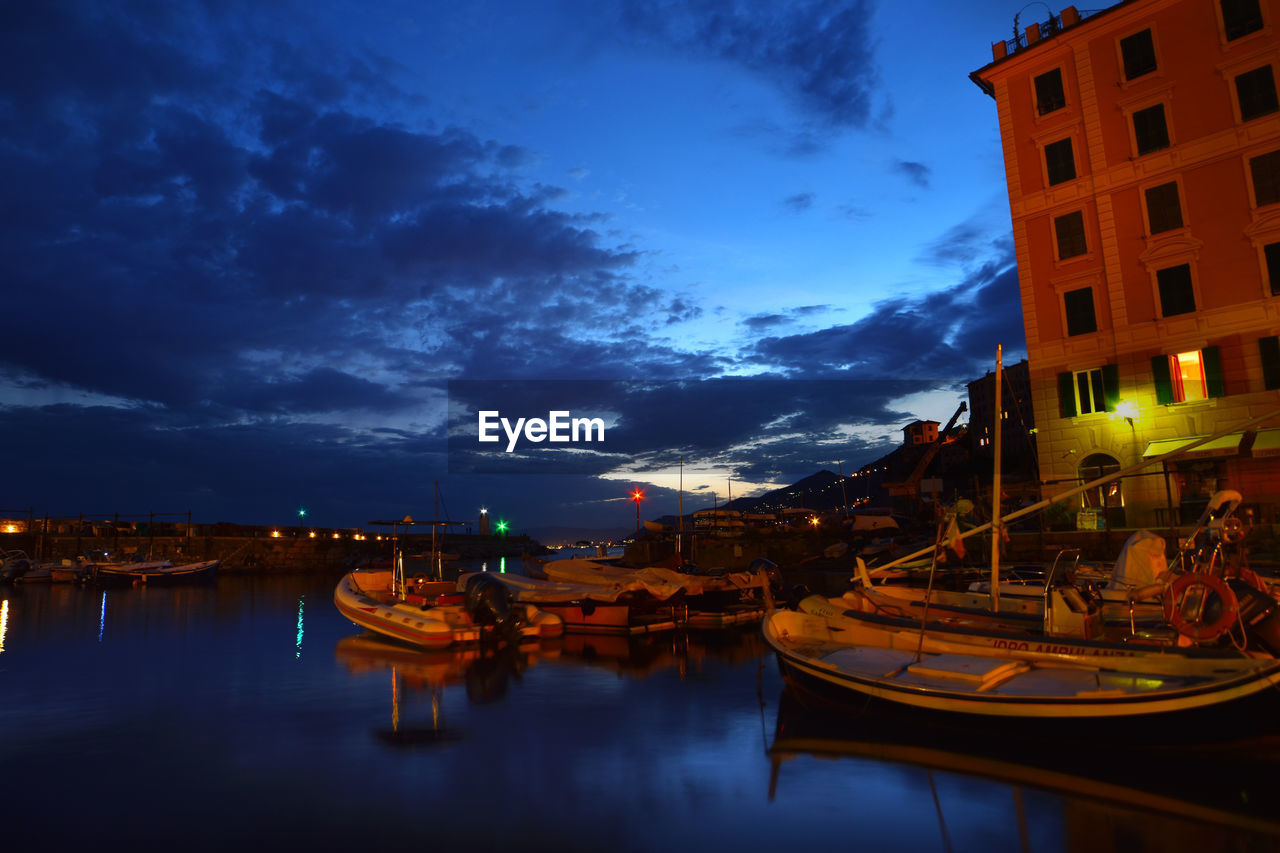 BOATS MOORED IN MARINA AT NIGHT