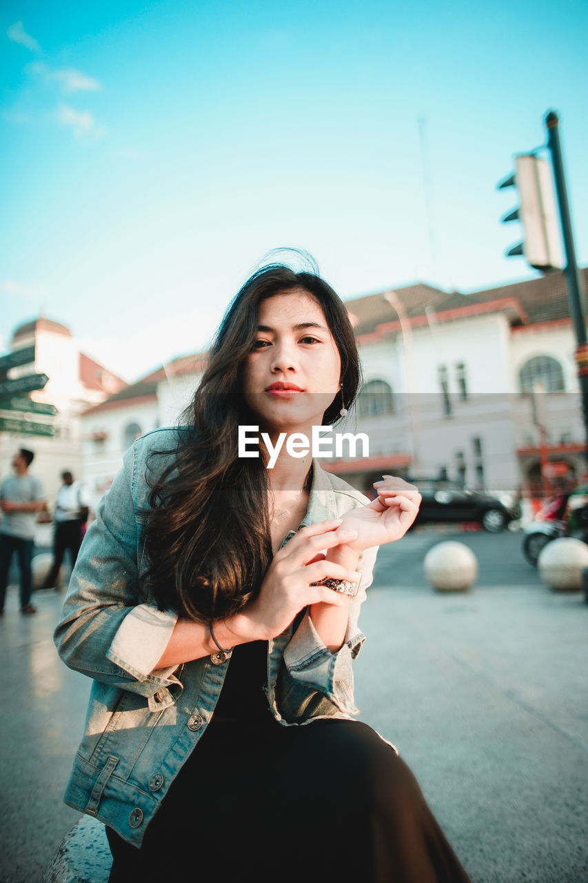 BEAUTIFUL YOUNG WOMAN HOLDING ICE CREAM ON STREET