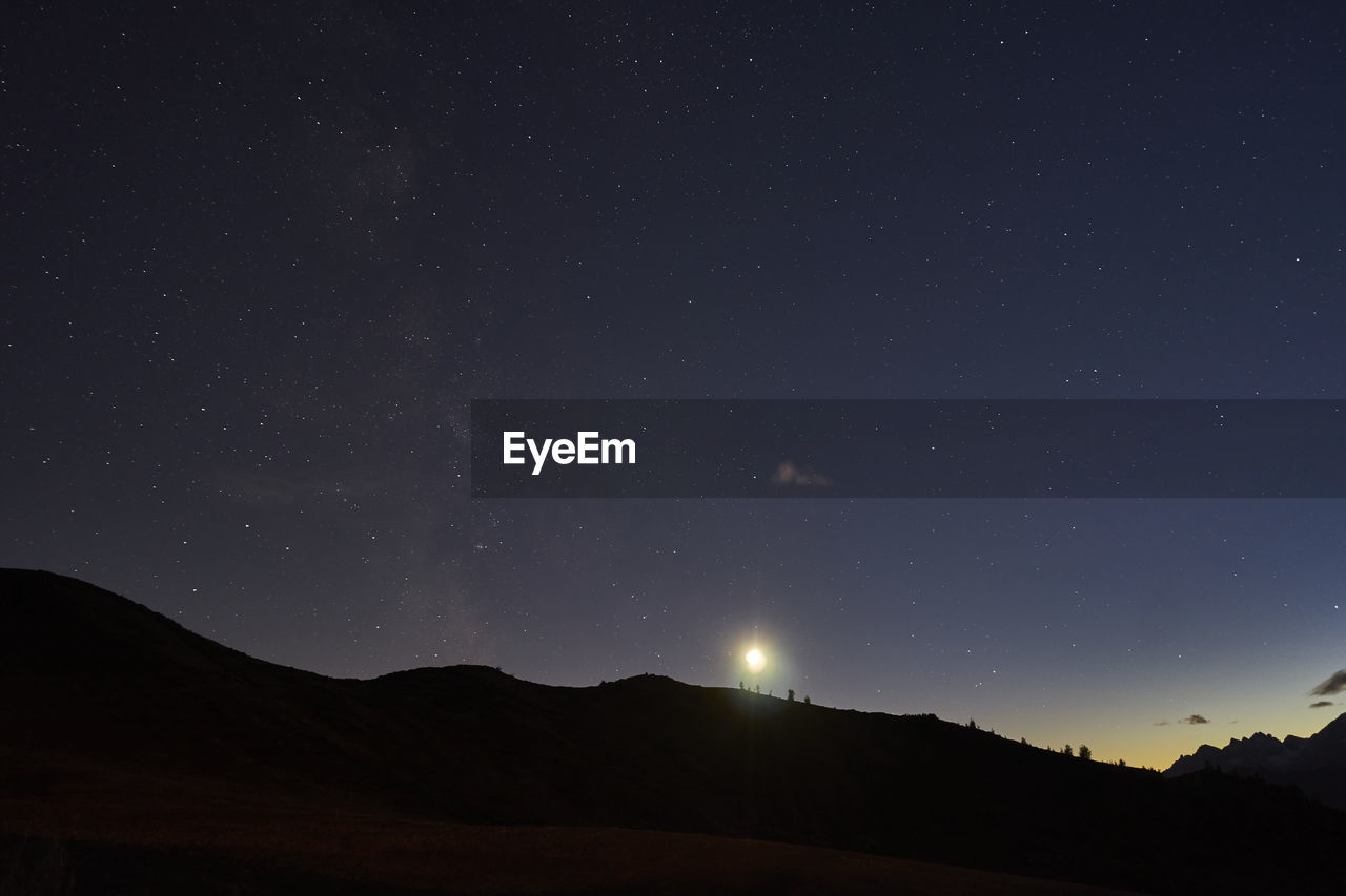 Scenic view of silhouette mountain against sky at night