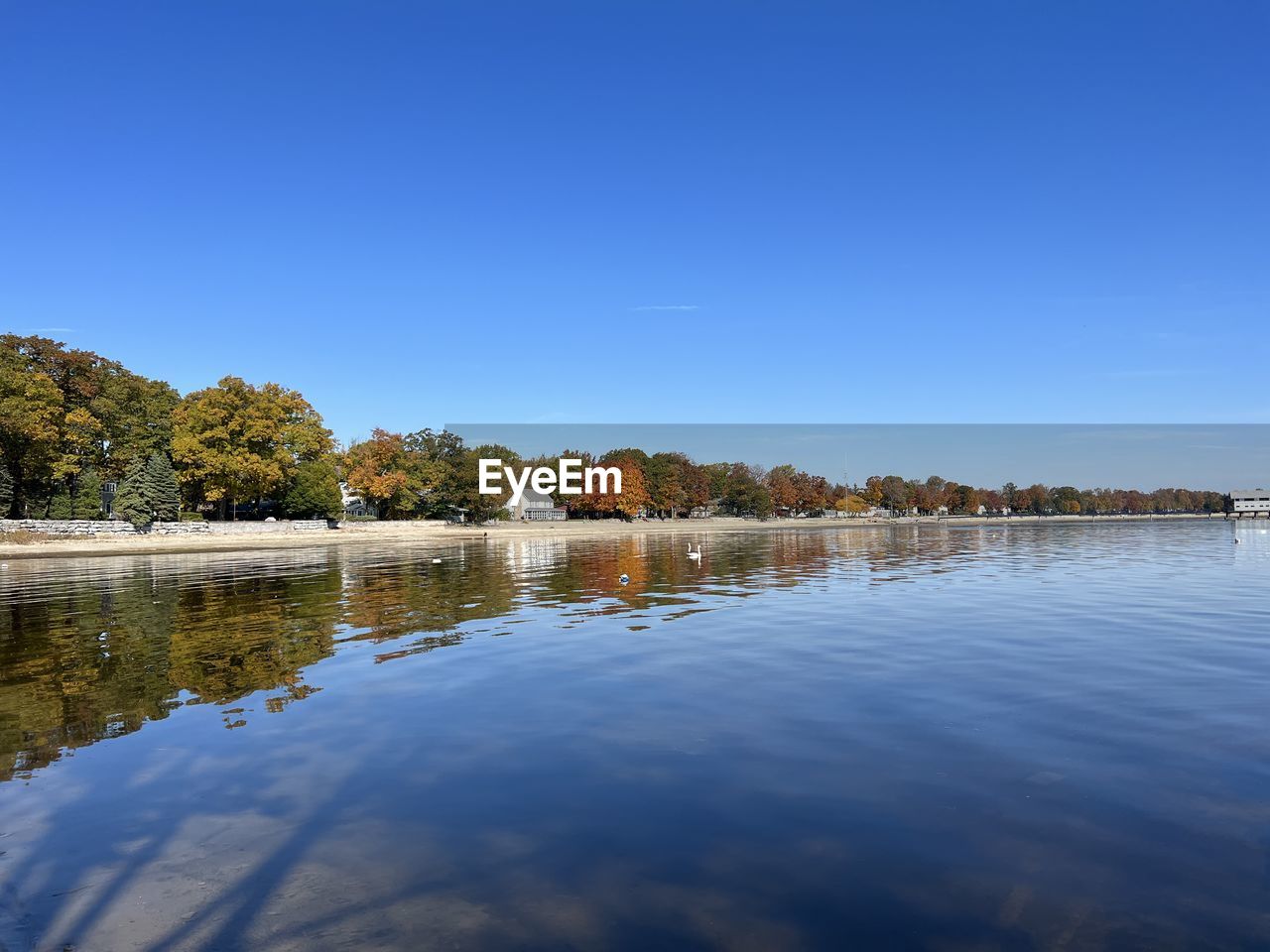 reflection, water, sky, river, shore, blue, nature, body of water, tree, morning, dusk, tranquility, scenics - nature, clear sky, environment, beauty in nature, plant, landscape, no people, reservoir, tranquil scene, land, outdoors, travel destinations, day, travel, copy space, horizon, sunlight, sunny, architecture, idyllic, tourism