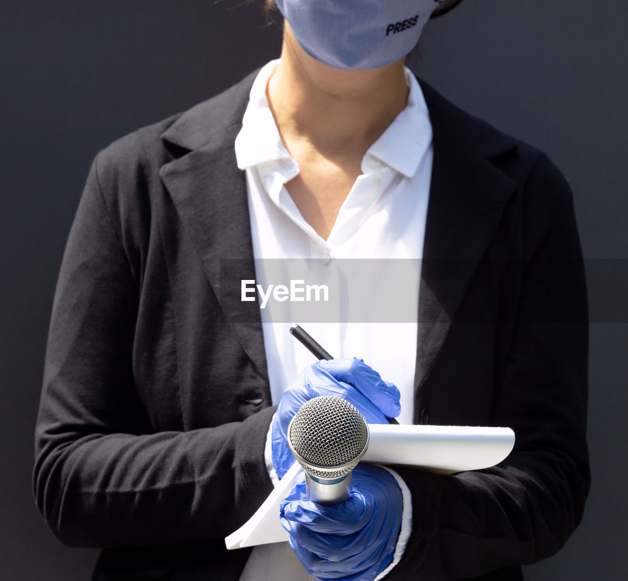 Female journalist wearing protective gloves and face mask against coronavirus covid-19 disease