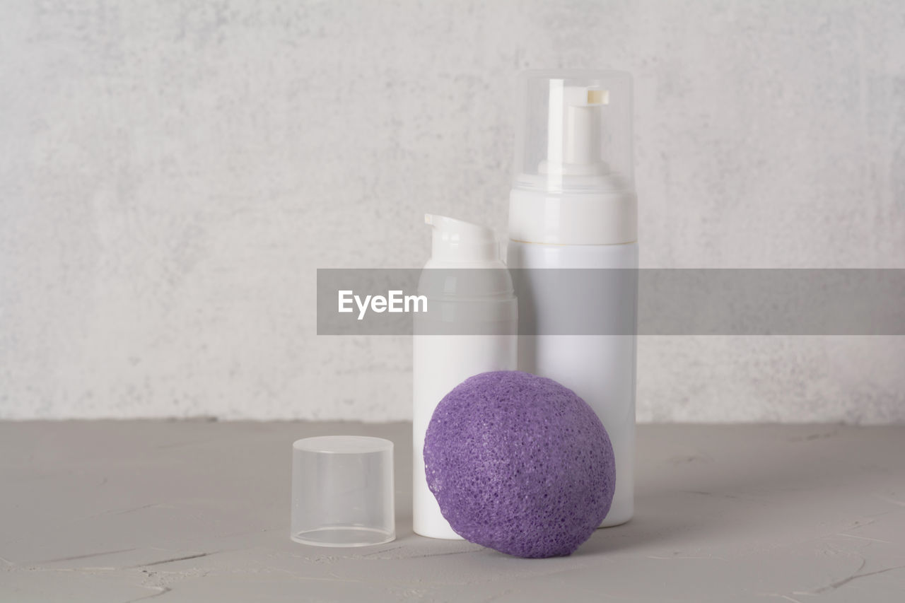 Beauty, spa and wellness concept. facial cosmetic products,konjac sponge on gray texture background.