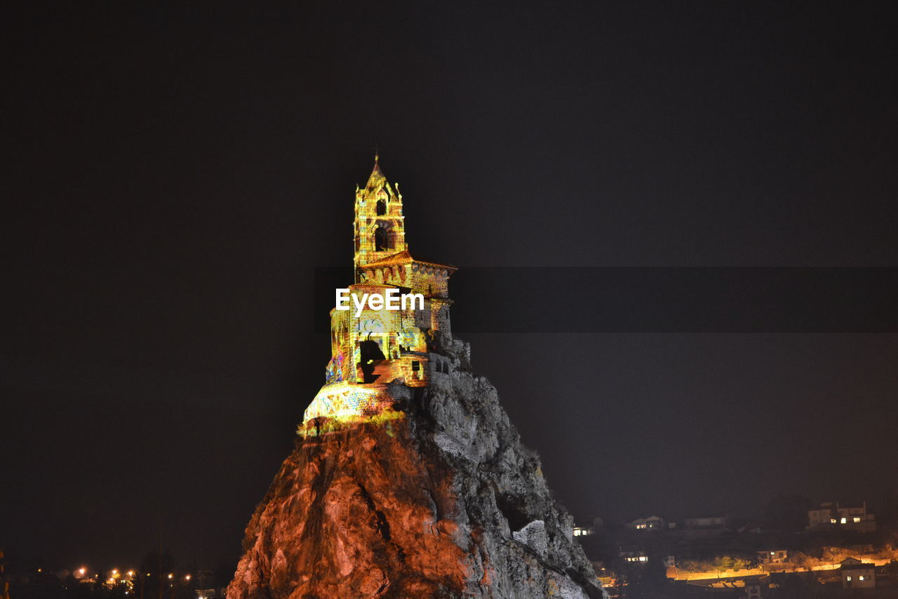 LOW ANGLE VIEW OF ILLUMINATED BUILDINGS AT NIGHT