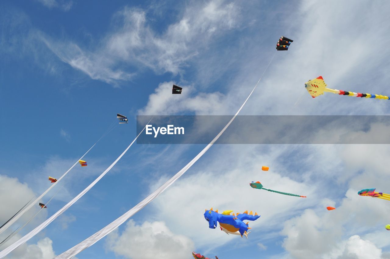 Low angle view of kites flying against sky