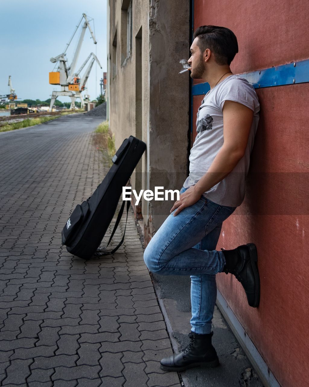 Side view of man standing against wall