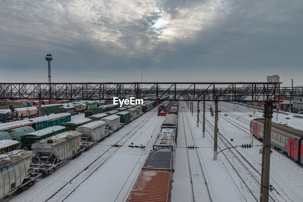 Railway station in winter with trains and freight cars on the track