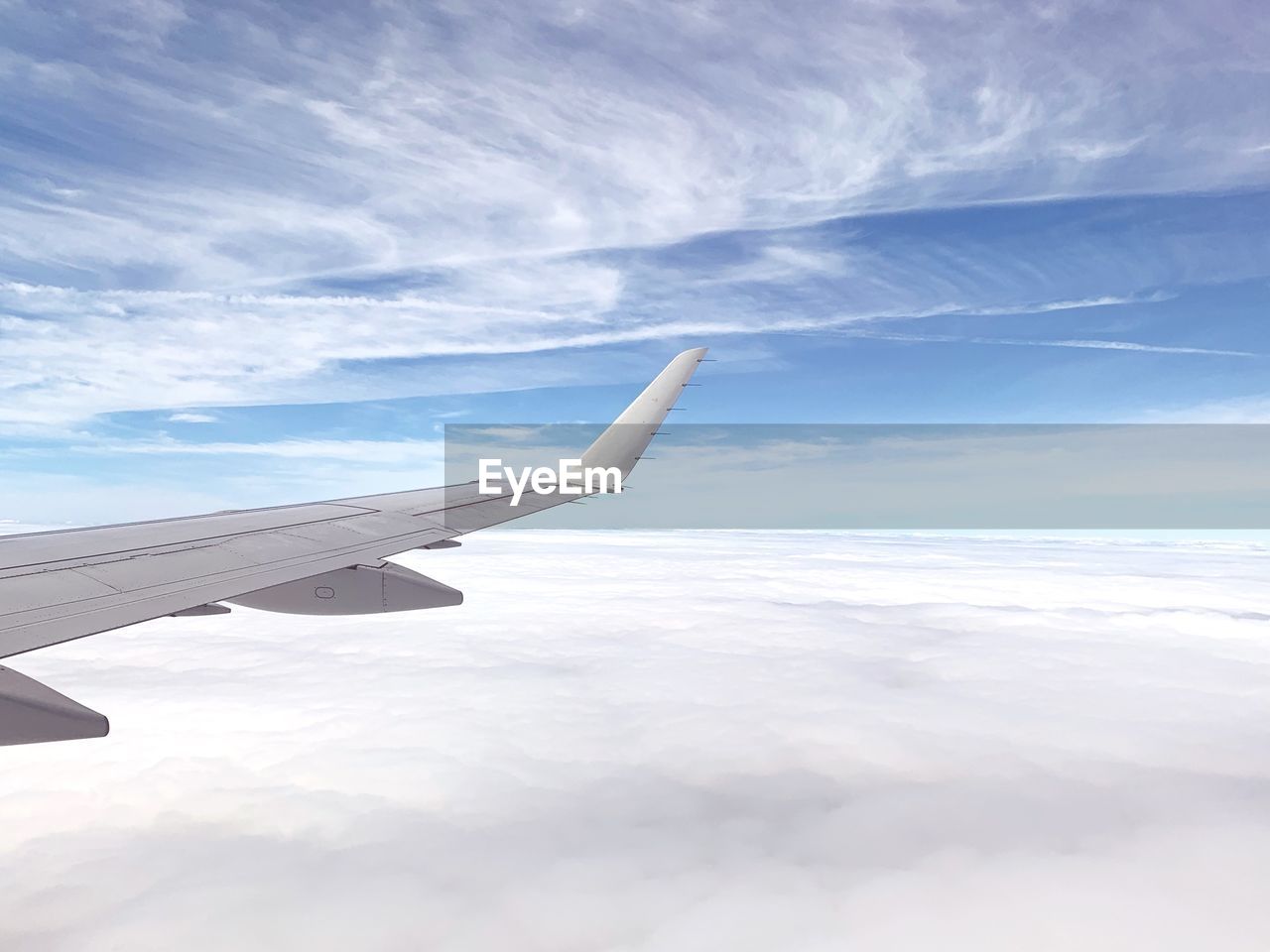 AERIAL VIEW OF AIRPLANE FLYING OVER CLOUDSCAPE