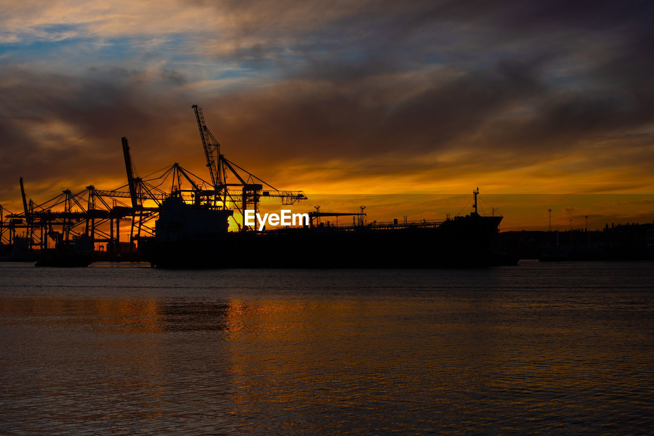 CRANES AT HARBOR DURING SUNSET