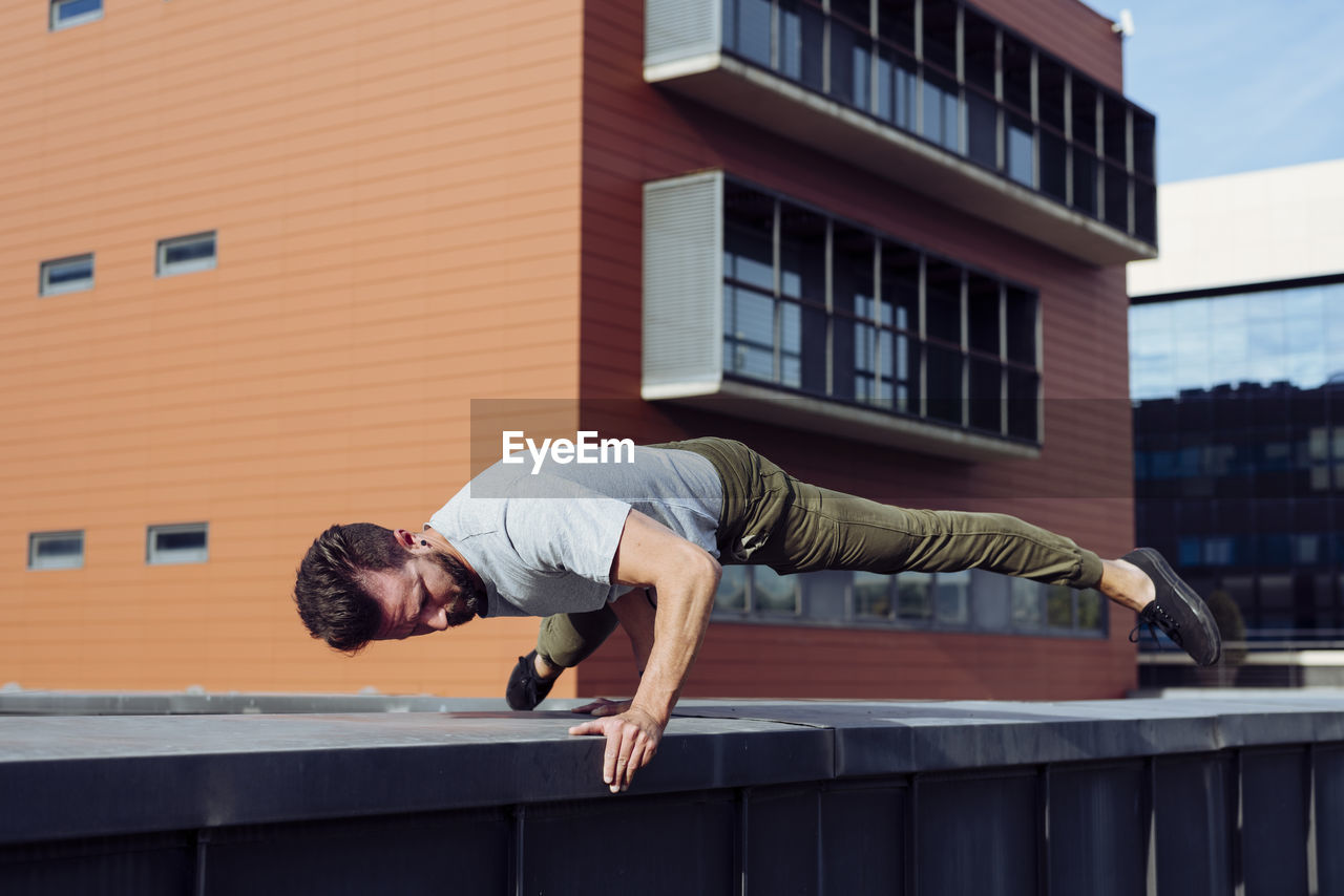 Athletic man doing parkour exercises outdoors person