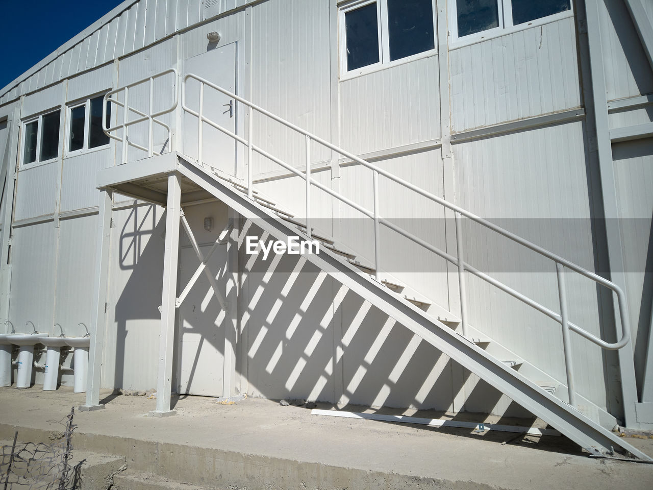 Metal stairway outside of mobile industrial building. newly built two-storey prefabricated building