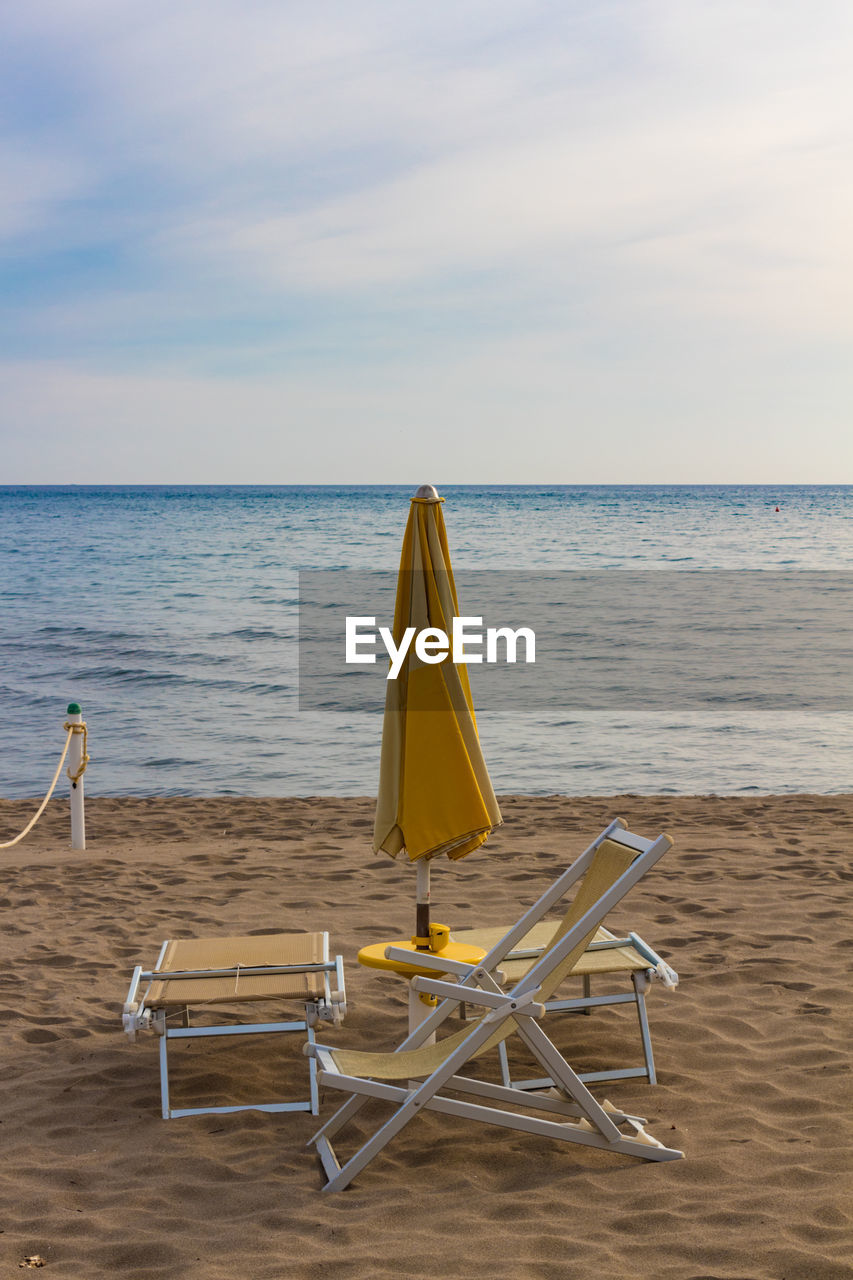 CHAIR ON BEACH AGAINST SKY