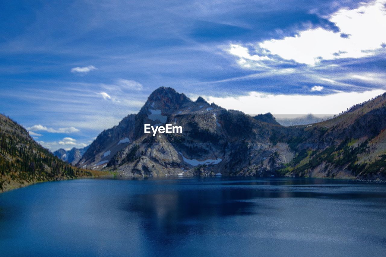 Scenic view of lake by mountains against sky