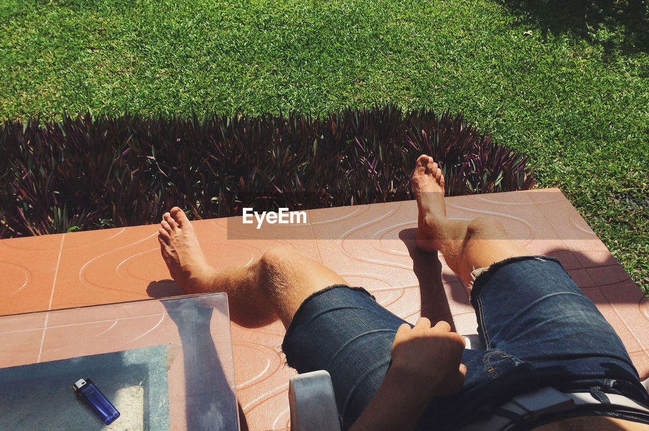 LOW SECTION OF WOMAN SITTING ON BENCH