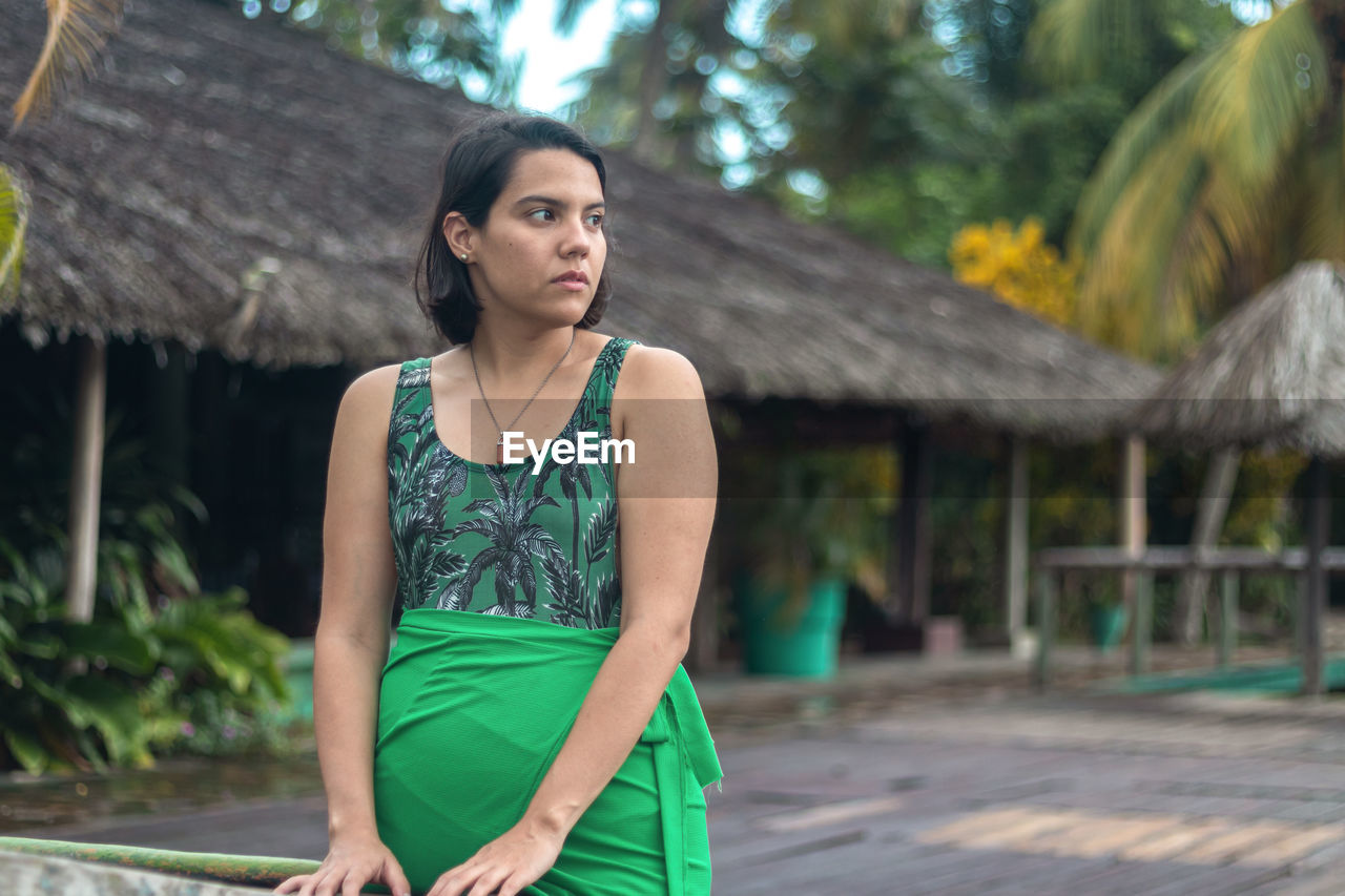 Woman poses in front of a tourist camp, while staring at the horizon