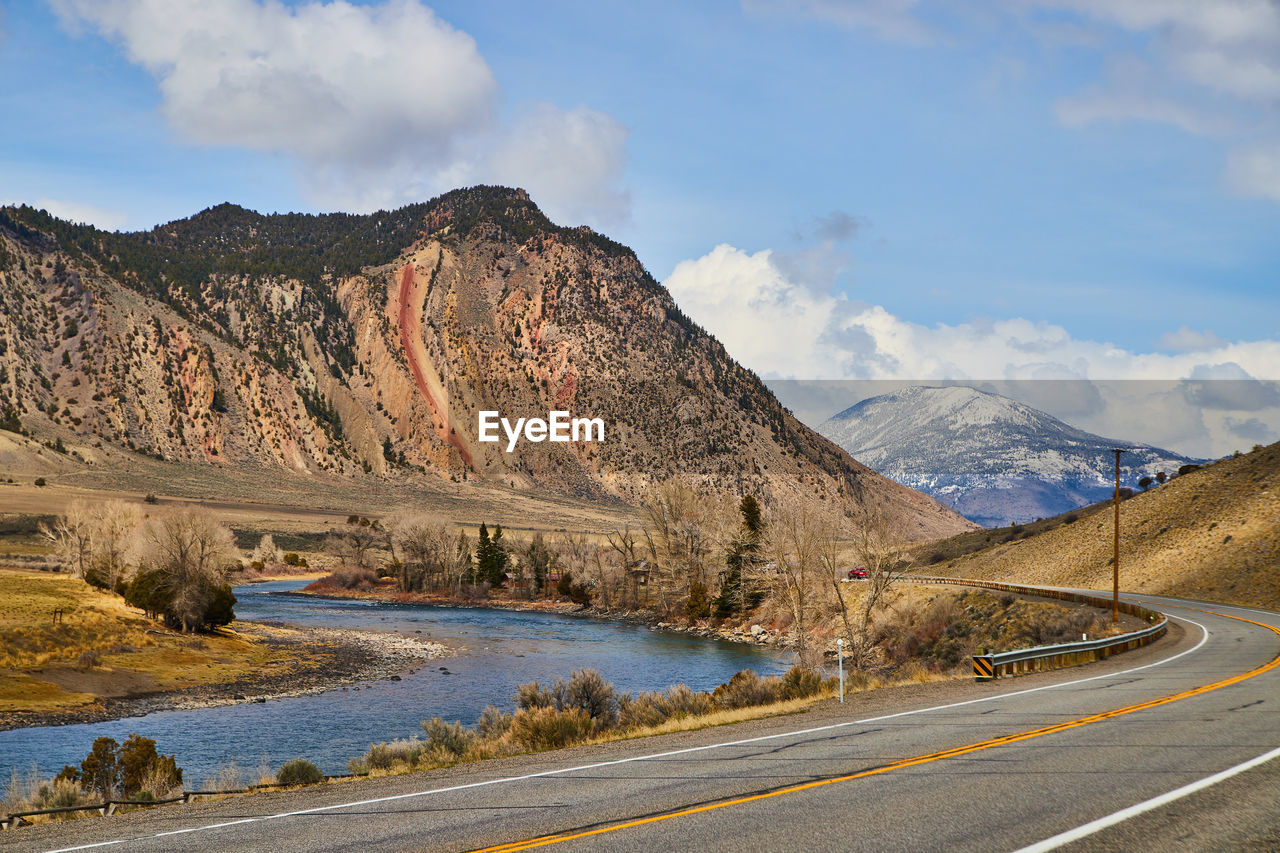 scenic view of road by mountains against sky