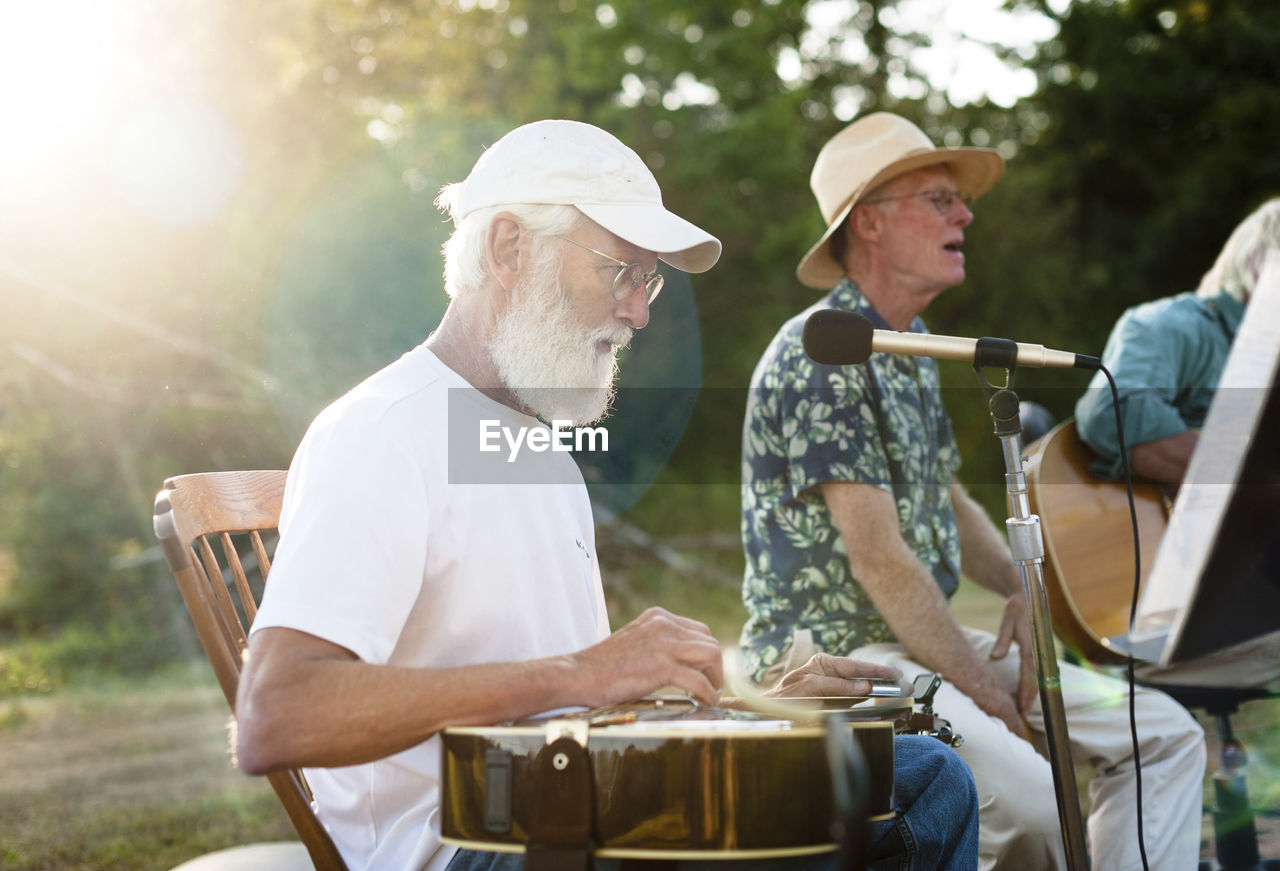 Man singing while friend playing guitar in yard