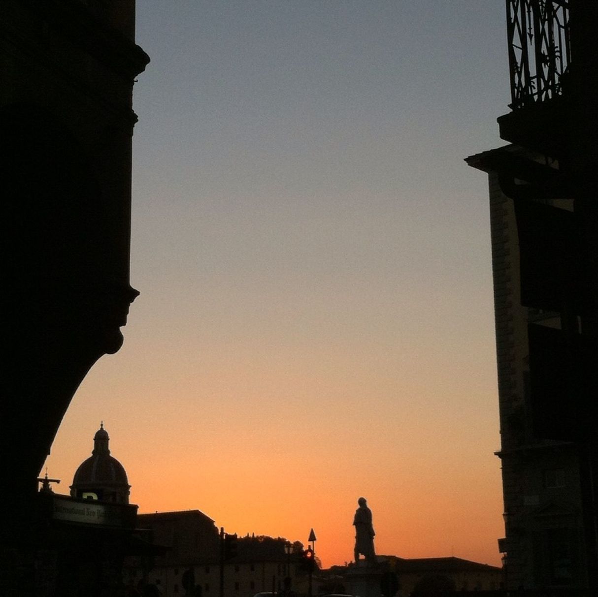 Silhouette of man standing on rooftop in city