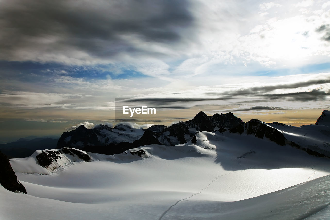 Scenic view of snow covered mountain against cloudy sky at swiss alps