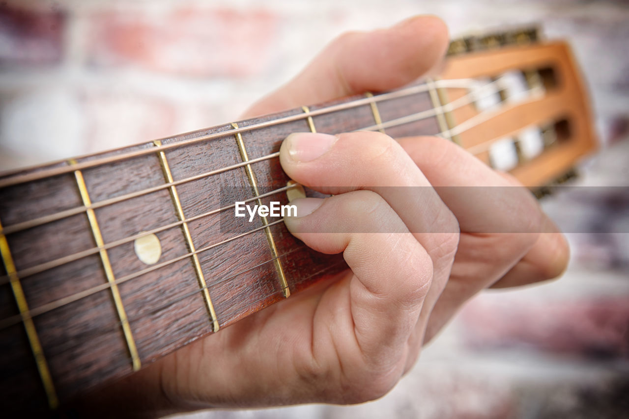 Cropped hand playing guitar