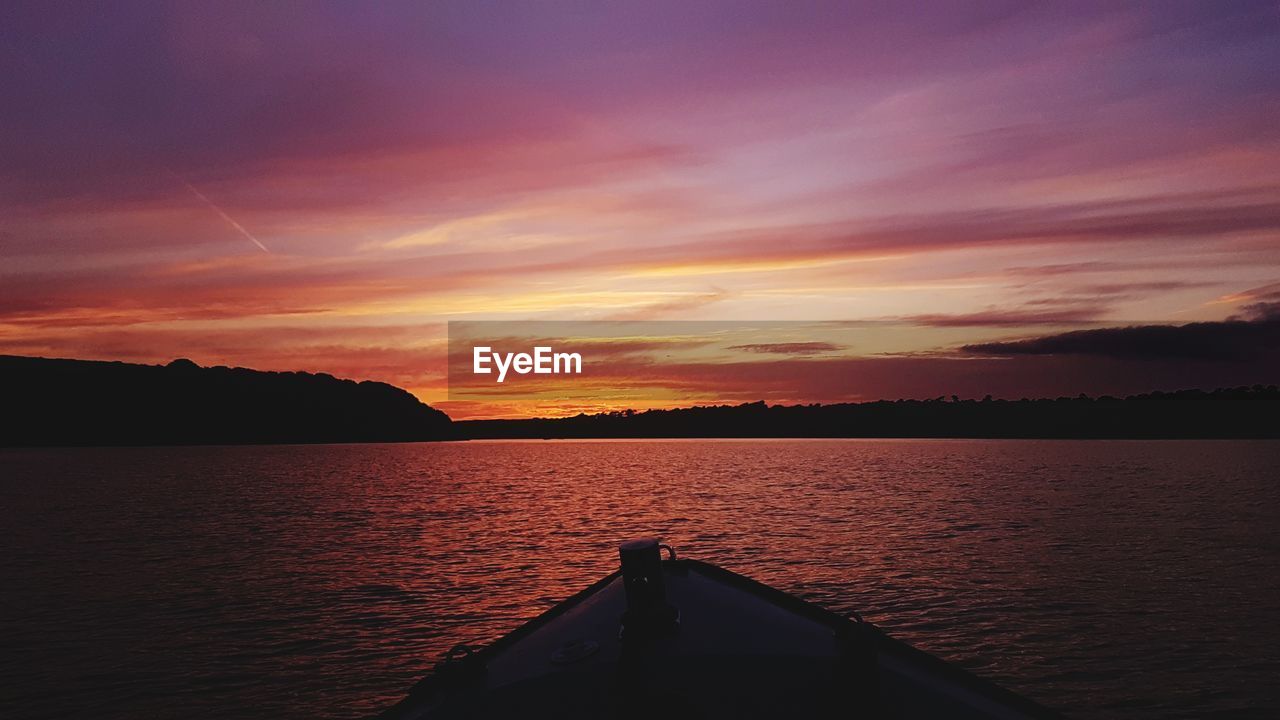 SCENIC VIEW OF LAKE AGAINST ORANGE SKY DURING SUNSET