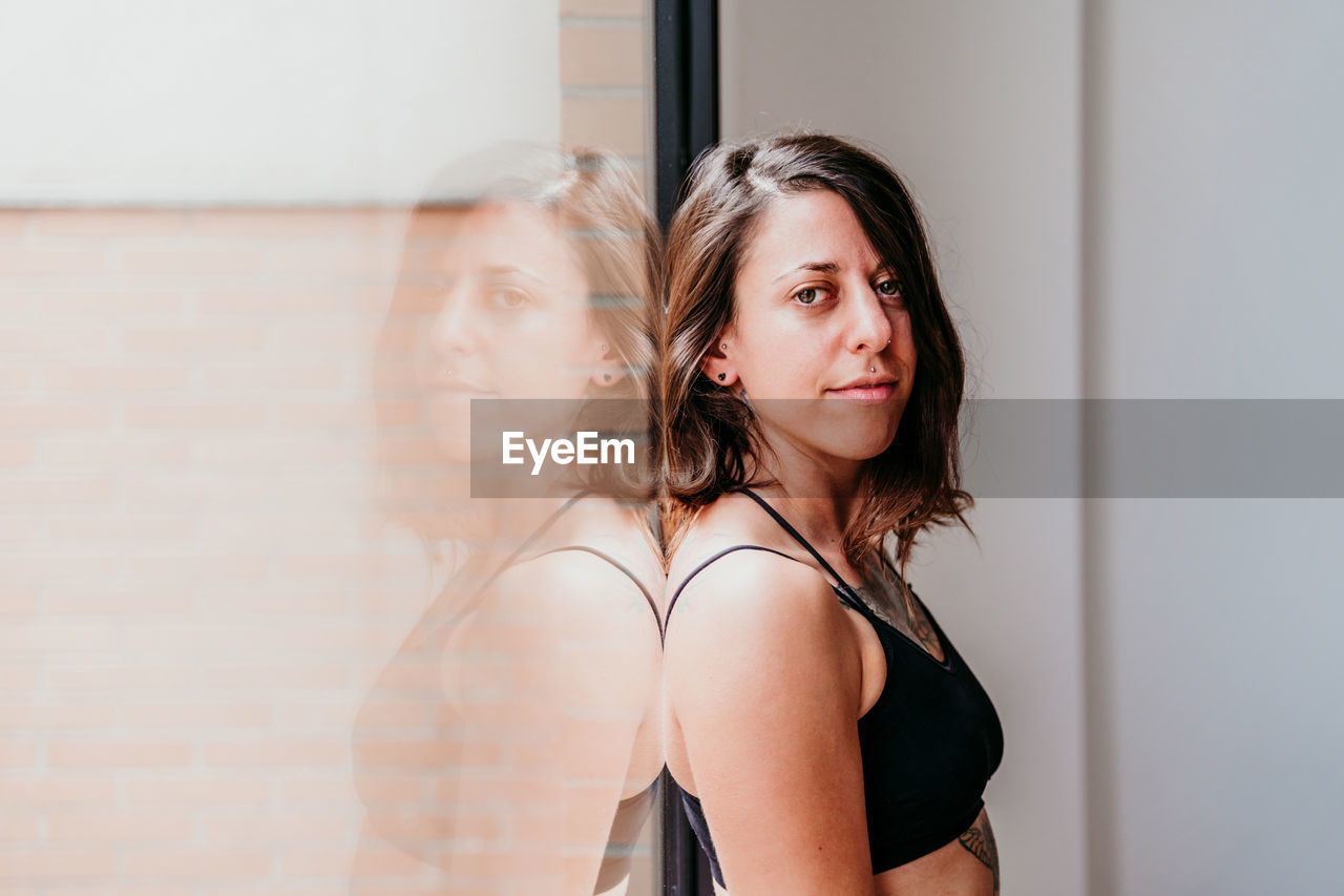 Close up portrait of muscular caucasian woman at gym standing by window. sport and healthy lifestyle