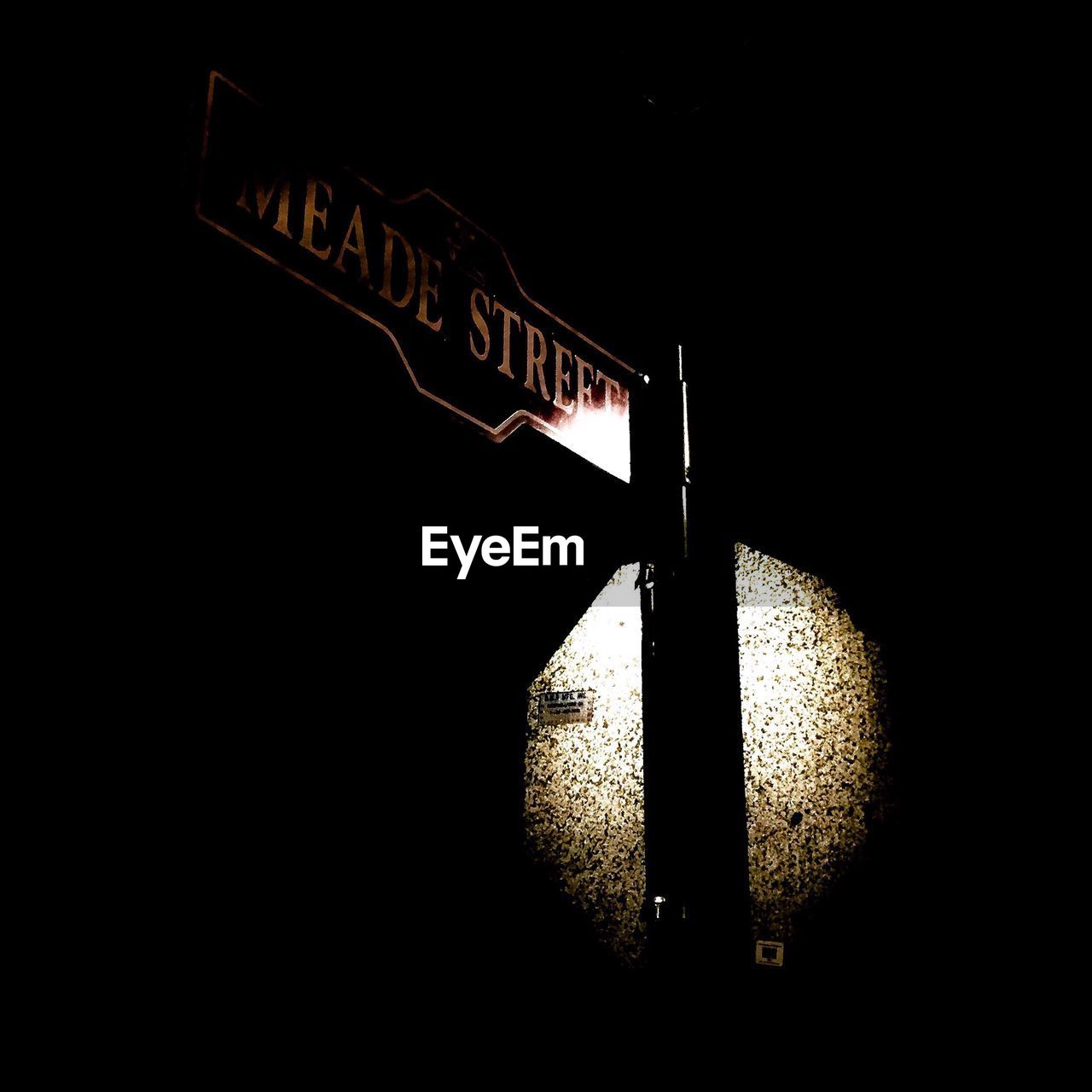 Low angle view of road sign at night