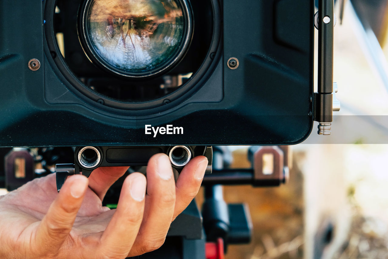 Cropped hand of man holding camera