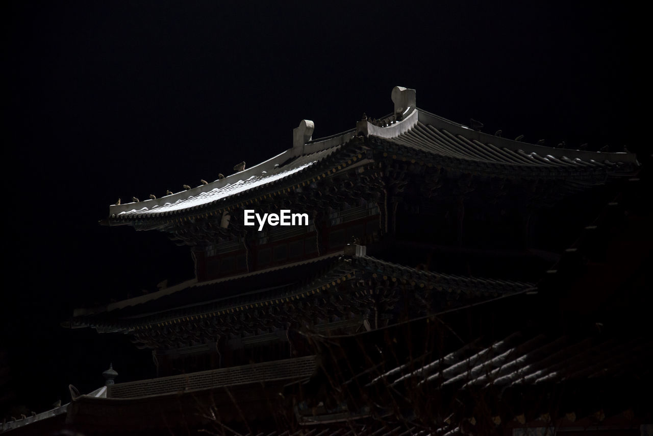 Low angle view of roof against sky at night