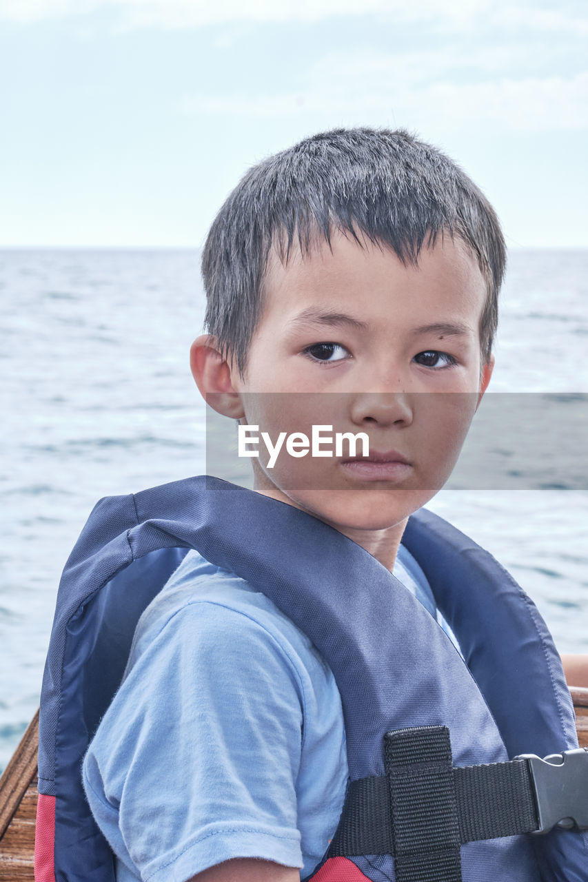 PORTRAIT OF BOY LOOKING AT SEA