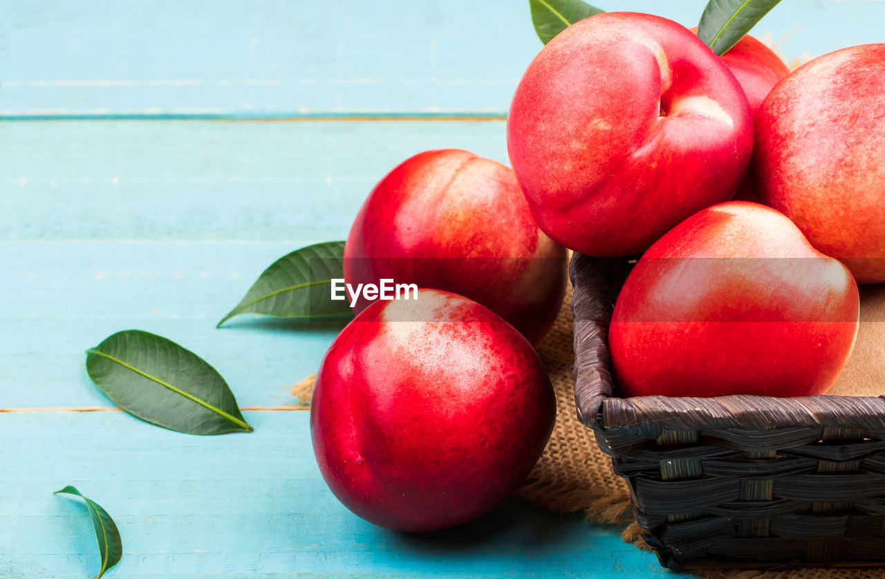 CLOSE-UP OF APPLES ON BASKET