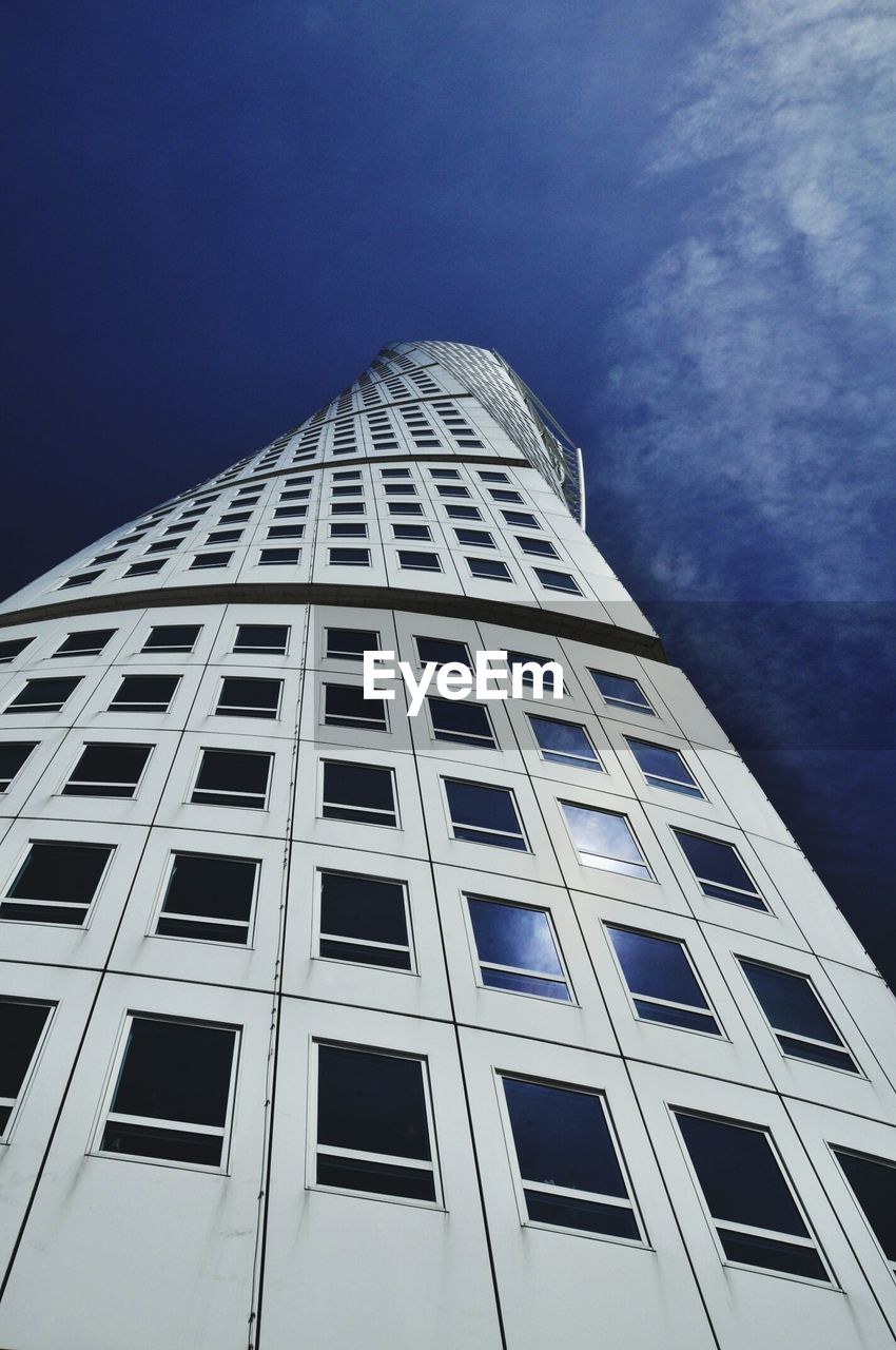 Low angle view of turning torso against sky