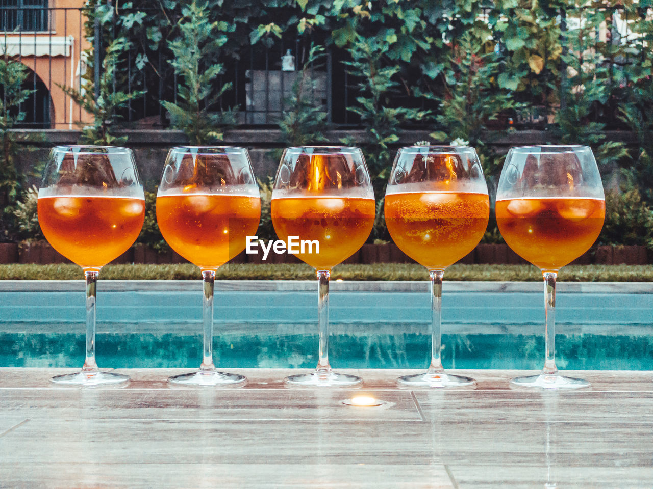 Close-up of aperol spritz against swimming pool