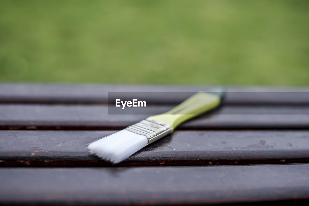 CLOSE-UP OF PEN ON TABLE OUTDOORS