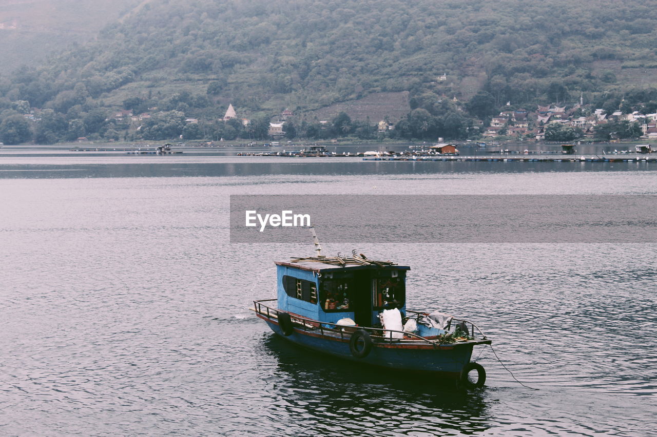 Fishing boat with a view of mountain at toba lake, north sumatra 