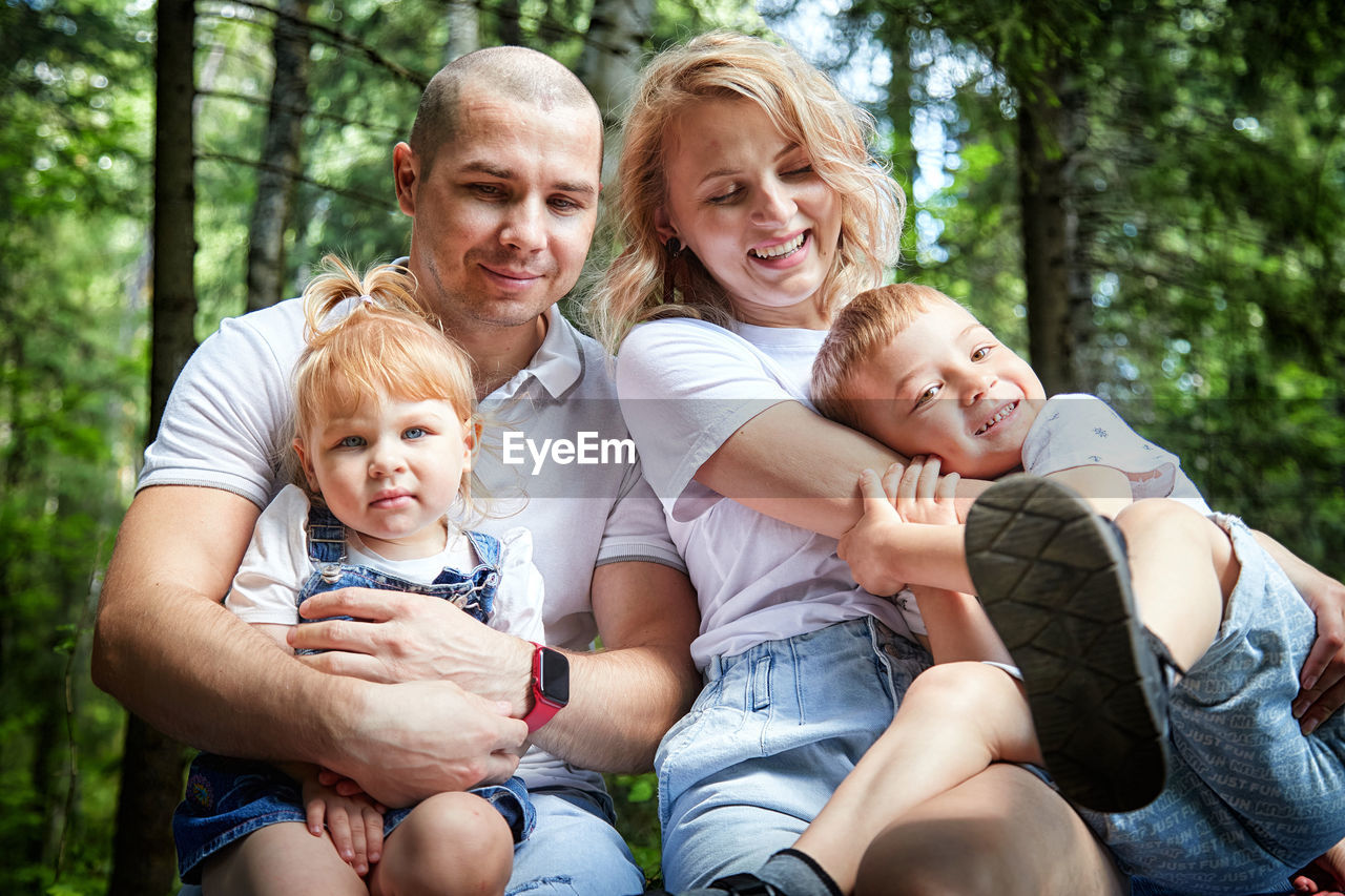 portrait of family sitting on field in park