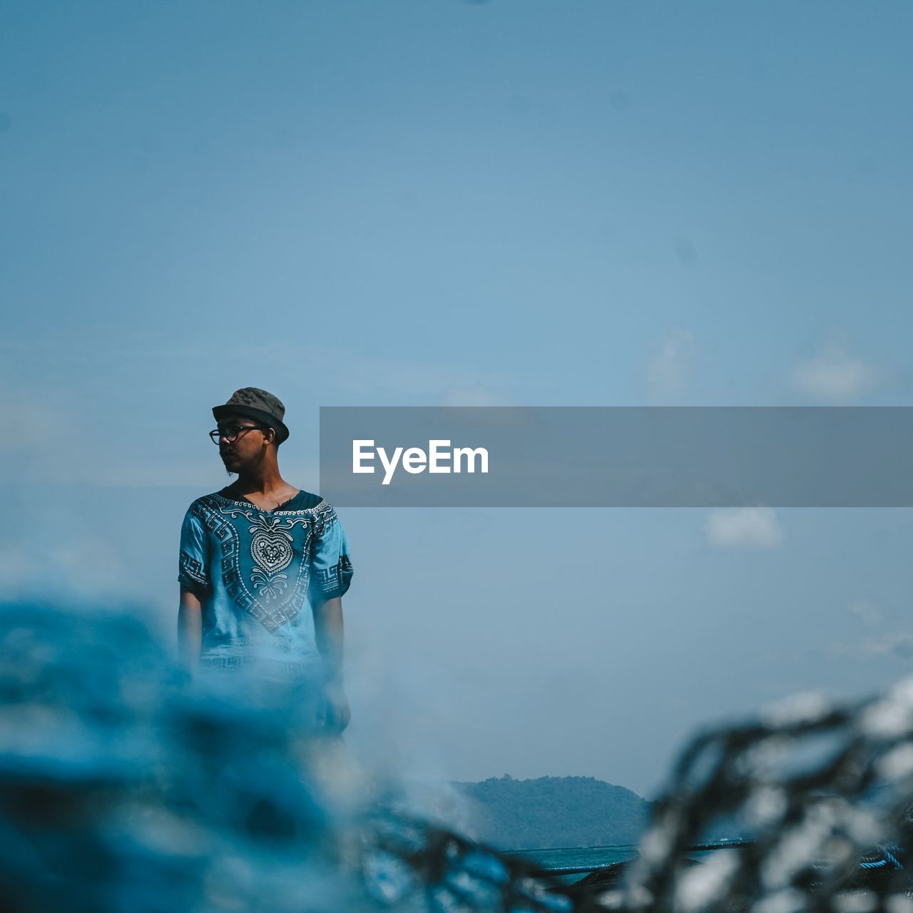 Young man looking at sea against sky