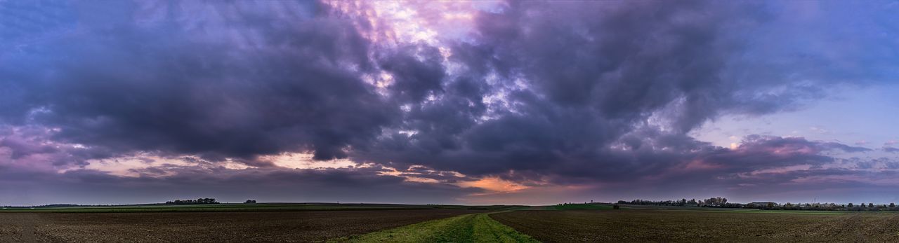 PANORAMIC VIEW OF FIELD AGAINST DRAMATIC SKY AT SUNSET