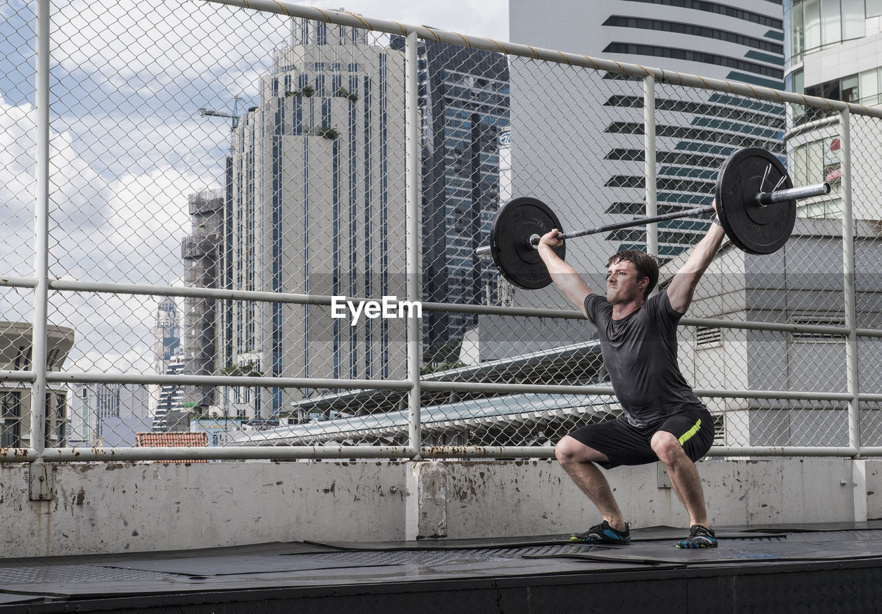 Man training at rooftop gym in bangkok