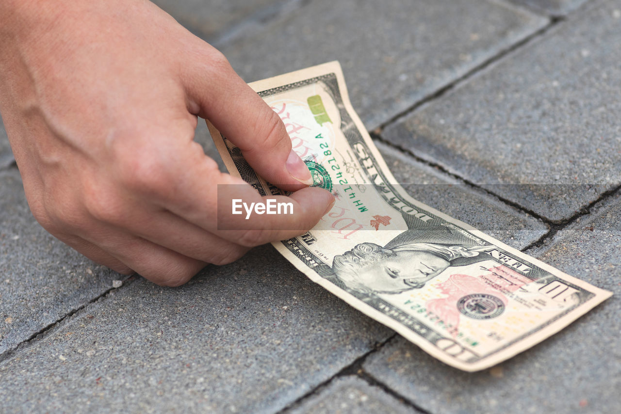 cropped hand of man holding paper currency