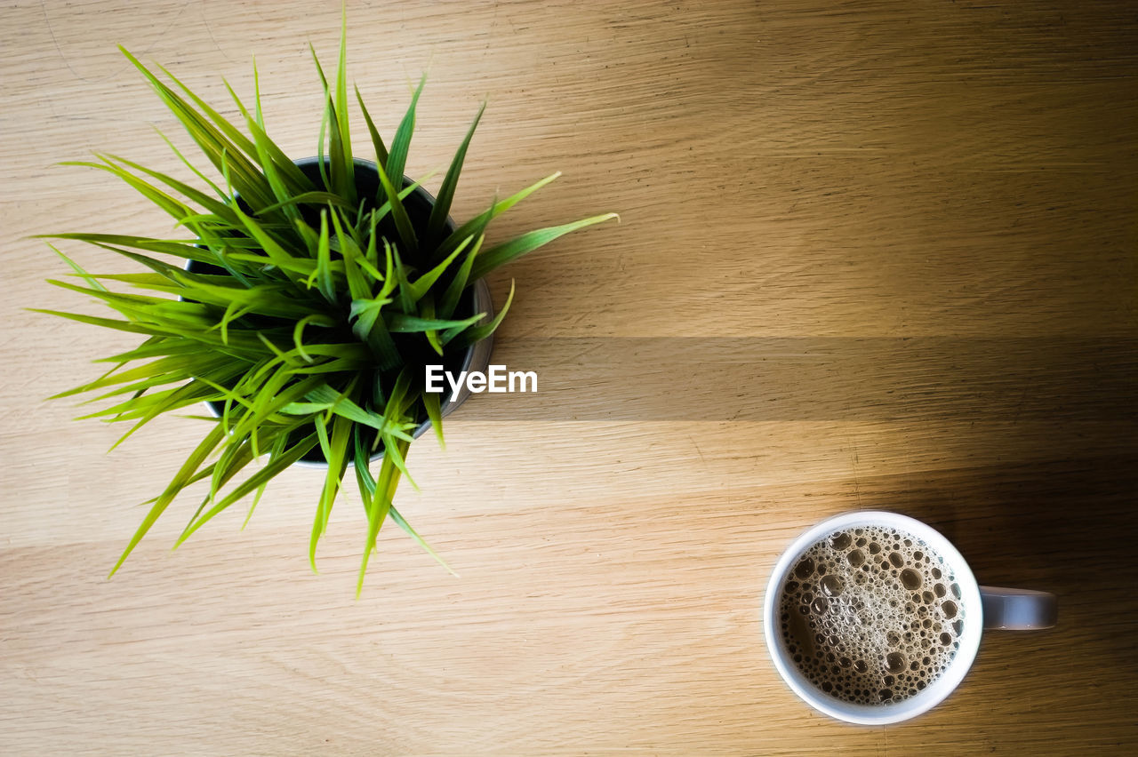 CLOSE-UP OF COFFEE CUP ON WOODEN TABLE