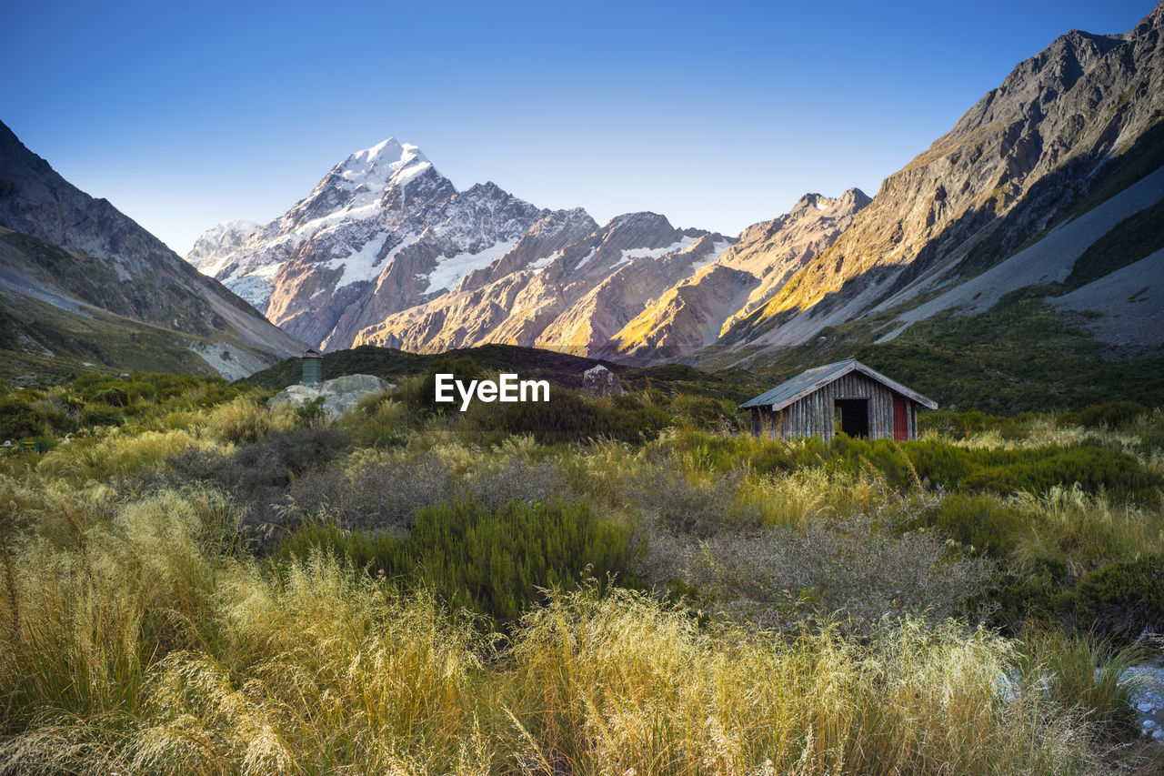 Scenic view of field and mountains against sky