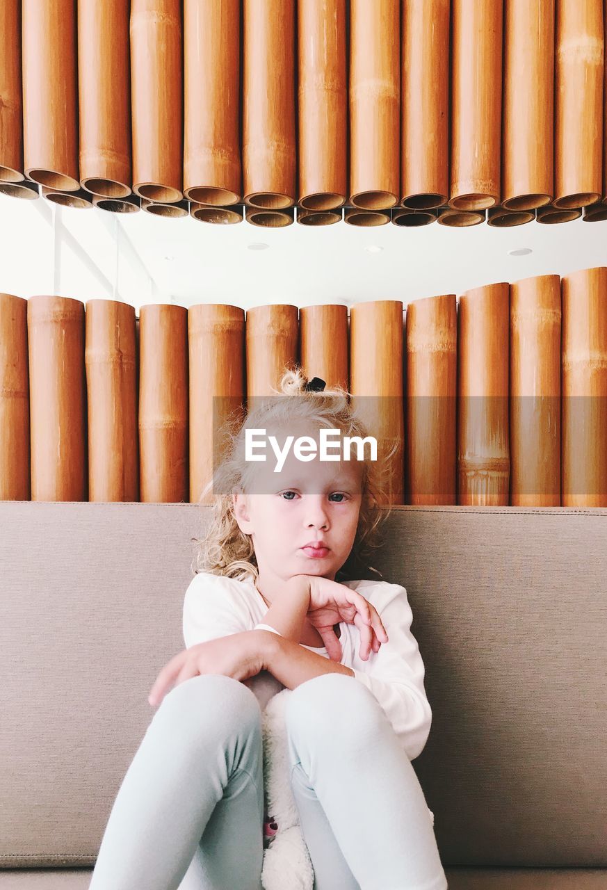 Portrait of cute girl sitting against decoration