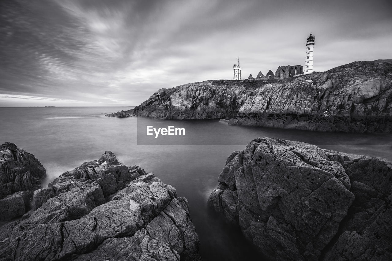 Rocks by sea against sky